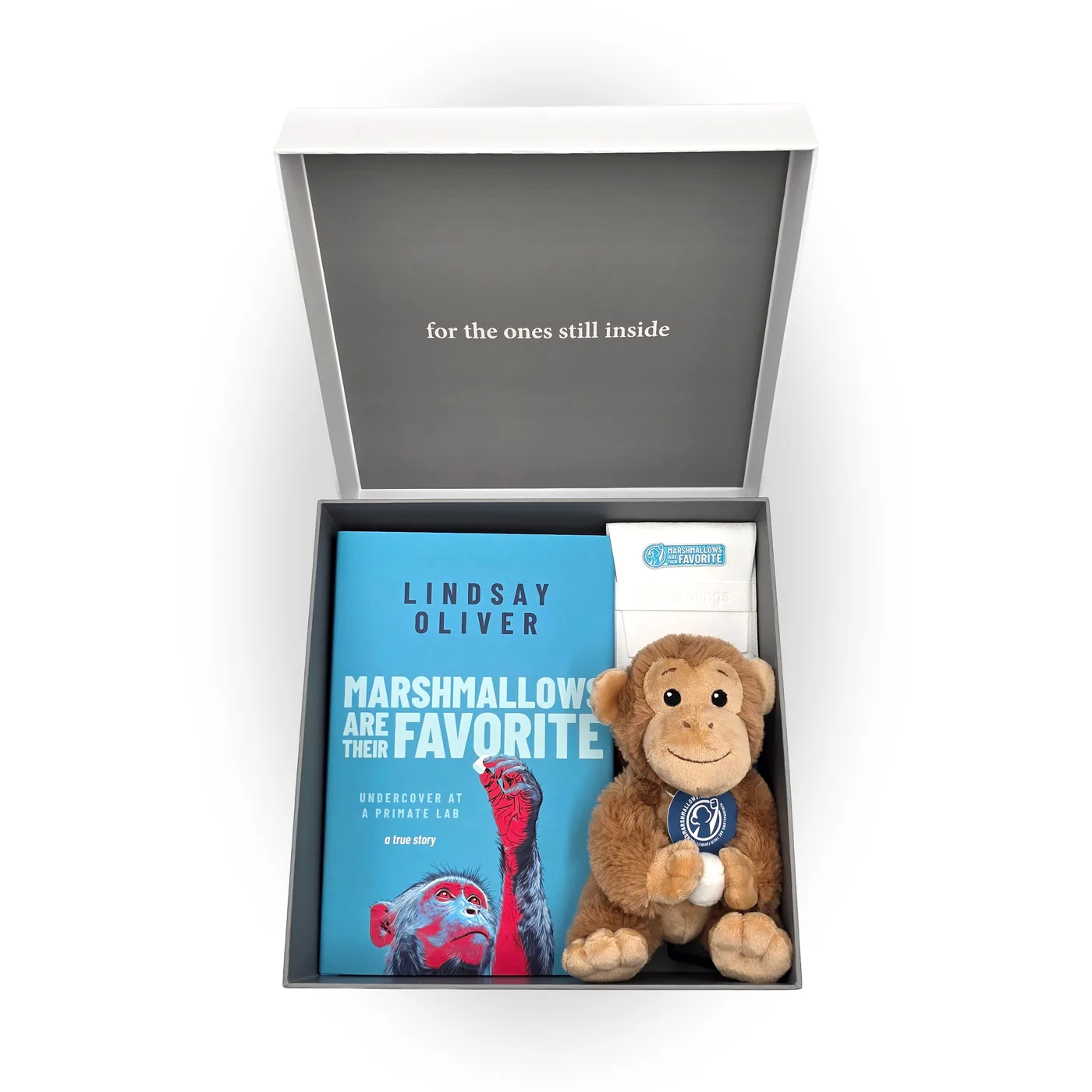 The open collector's box holding the signed book, a plush monkey and a pouch